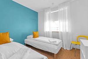 a blue room with two beds and a window at Charming, 2 Bedroom Seaside Apartment in Reykjavík