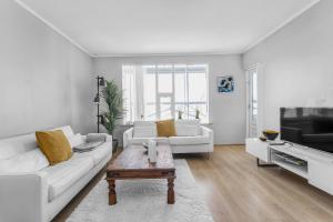 a white living room with a couch and a coffee table at Charming, 2 Bedroom Seaside Apartment in Reykjavík