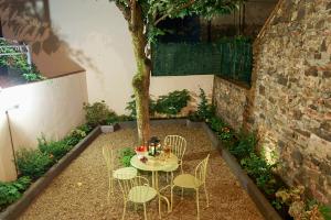 einen Tisch und Stühle in einem Innenhof mit einem Baum in der Unterkunft Greenhouse in Florenz