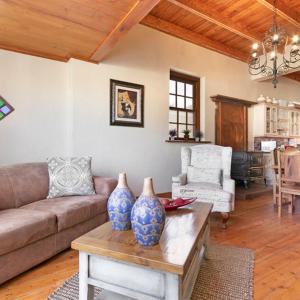 Una sala de estar con un sofá y dos jarrones sobre una mesa. en J's Audacious Living Montagu Self Catering, en Montagu
