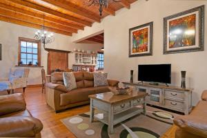 Una sala de estar con un sofá y un televisor. en J's Audacious Living Montagu Self Catering, en Montagu