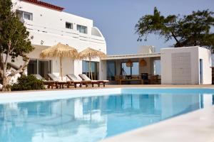 a swimming pool in front of a villa at Hélène Holidays - Hotel Boutique in Corralejo