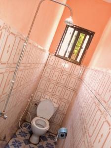 bagno con servizi igienici e finestra. di California Lodge a Bagamoyo