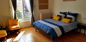 a bedroom with a bed with blue and yellow pillows at La maison des dentelliers in Calais