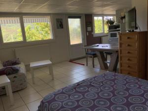 een kamer met een bed en een keuken met een bureau bij Chez DouKine in Beure