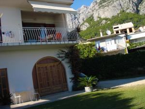uma casa com uma grande porta de madeira e uma montanha em Apartments Vrisika-family apartment em Makarska