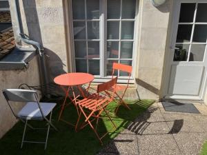 2 Stühle und ein Tisch vor einem Haus in der Unterkunft Studio centre historique de La Rochelle in La Rochelle