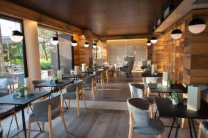 a restaurant with tables and chairs and windows at Alevic Hotel Sirmione in Sirmione
