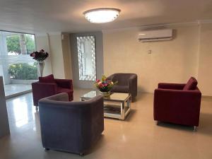 a living room with couches and a table and flowers at Hotel Puerta de Oro in Barranquilla