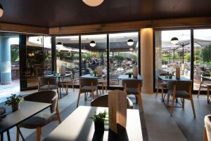 a restaurant with tables and chairs and windows at Alevic Hotel Sirmione in Sirmione
