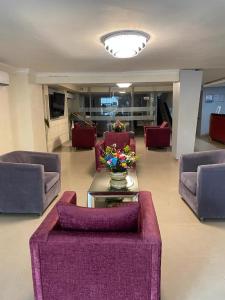 un vestíbulo con sofás y una mesa con un jarrón de flores en Hotel Puerta de Oro, en Barranquilla