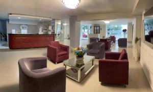 - une salle d'attente avec des chaises et une table fleurie dans l'établissement Hotel Puerta de Oro, à Barranquilla