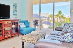 a living room with a couch and a tv at Hamilton House 206 in Clearwater Beach