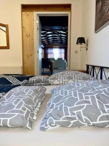 1 dormitorio con cama con edredón y almohadas en BeejMig, en Arcen