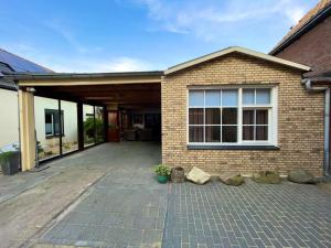 a brick house with a large patio at BeejMig in Arcen