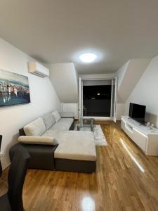 uma sala de estar com um sofá e uma televisão em Apartman Anton em Zagreb