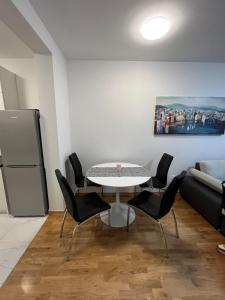 a dining room with a table and chairs and a couch at Apartman Anton in Zagreb