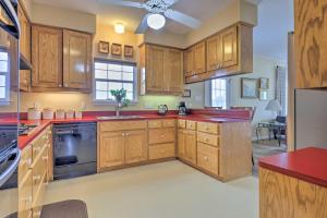 a kitchen with wooden cabinets and red counter tops at Fox Ridge Farmhouse - Hill Country Getaway! in San Marcos