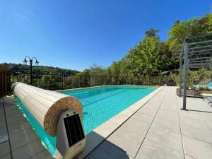 a swimming pool with a pool noodle next to a swimming pool at Gîtes Le Bouzet in Salavas