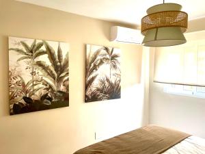 una camera da letto con tre immagini di palme sul muro di Piso centrico en calle Luis Vives 1, Benalmadena a Benalmádena