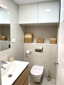 bagno con servizi igienici bianchi e lavandino di Piso centrico en calle Luis Vives 1, Benalmadena a Benalmádena