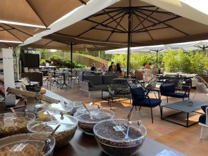 a table with bowls and umbrellas on a patio at Alevic Hotel Sirmione in Sirmione