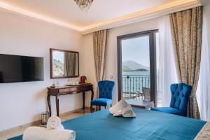 a hotel room with a bed and a desk and a window at Villa Afrodita Lake View in Ohrid