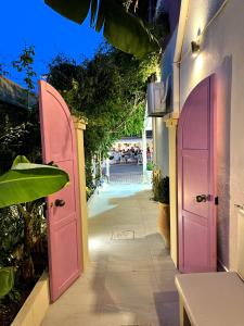 a pair of pink doors on the side of a building at Carmena Residence in Skala Kefalonias