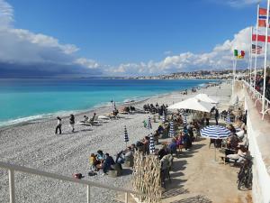 tłum ludzi siedzących na plaży w obiekcie AM STUDIO NICE w Nicei