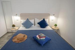 a bed with two hats and two pillows on it at Dimora del Corso - Rooms in Mattinata