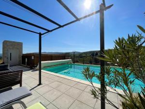 a swimming pool in a house with a patio at Gîtes Le Bouzet in Salavas