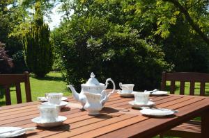 a wooden table with tea sets on top of it at The Grange Court Hotel in Rockbeare +21 photos