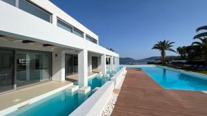 a villa with a swimming pool and a house at LeBlanc Luxurious Beachfront Villa by Goutos Luxury Living in Ermioni