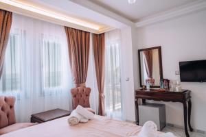a bedroom with a bed and a desk and a window at Villa Afrodita Lake View in Ohrid