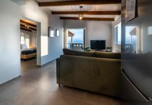a living room with a couch and a television at IONIAN BLUE SUITE in Preveza