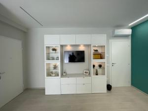 biała szafka z telewizorem w pokoju w obiekcie Otium Rooms / Camere e Appartamenti w mieście Morrovalle