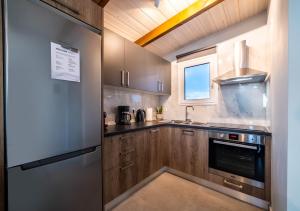 a kitchen with wooden cabinets and a stainless steel refrigerator at IONIAN BLUE SUITE in Preveza
