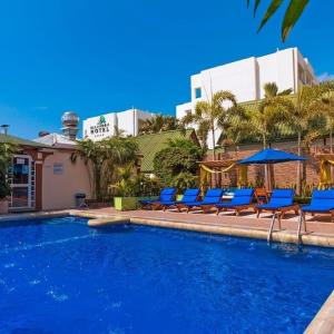 una piscina con sillas y sombrillas azules en Hotel Balandra, en Manta