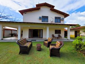 a yard with couches and chairs in front of a house at Casa de praia com piscina e playground in Vila Velha