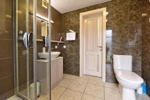 a bathroom with a toilet and a sink at Kotedžai GULBĖS TAKAS Šventojoje in Šventoji +40 photos