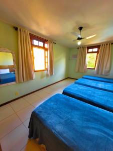 a bedroom with three beds and two windows at Casa de praia com piscina e playground in Vila Velha +41 photos