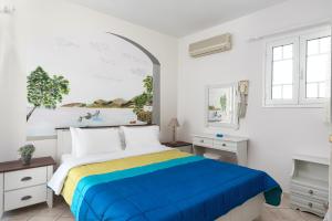 1 dormitorio con 1 cama y una pintura en la pared en Noe Rooms, en Tinos