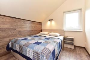 a small bedroom with a bed and a window at Kotedžai GULBĖS TAKAS Šventojoje in Šventoji
