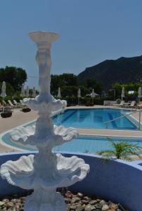 a white fountain sitting in the middle of a pool at Kokalakis Hotel in Kefalos
