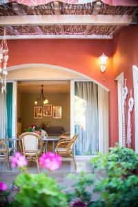 patio ze stołem, krzesłami i kwiatami w obiekcie Helen Corfu House w Korfu