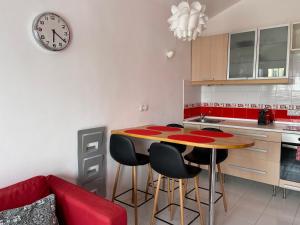 kuchnia ze stołem, krzesłami i zegarem w obiekcie Cotillo Lagoons Apartment w mieście Cotillo