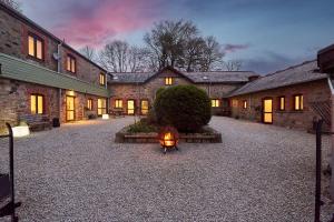 un patio de un antiguo edificio de piedra con una linterna en The Roost - The Cottages at Blackadon Farm en Ivybridge