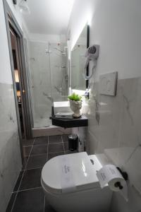 a white bathroom with a toilet and a shower at Relais Manzoni in Rome