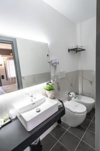 a bathroom with a sink and a toilet and a mirror at Relais Manzoni in Rome