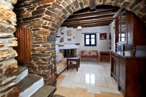 a living room with a stone wall and an archway at Tinos Habitart in Triandáros